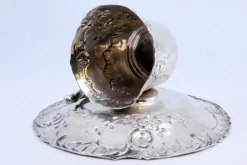 Tasse und Untertasse aus geprägtem Silber mit floralen Motiven